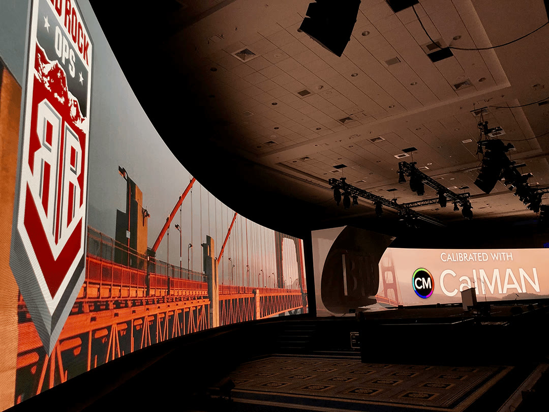 Curved LED wall showing a Calibrated with Calman screen, Red Rock OPS badge in view